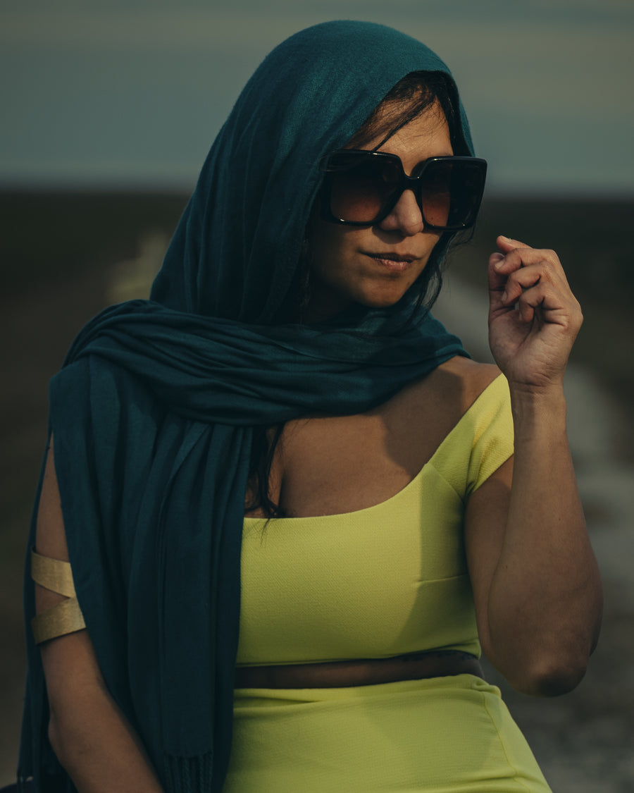 Outdoor fashion portrait of a woman in a teal headscarf and lime green set