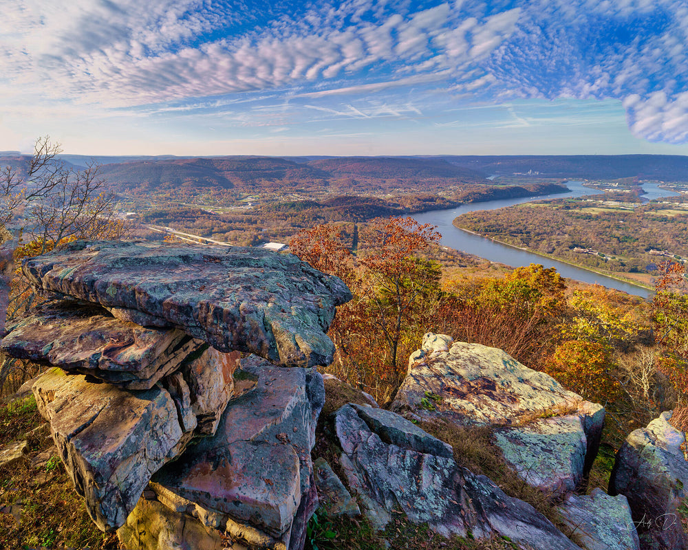 Rocky overlook above a river bend with autumn colour and a mackerel sky