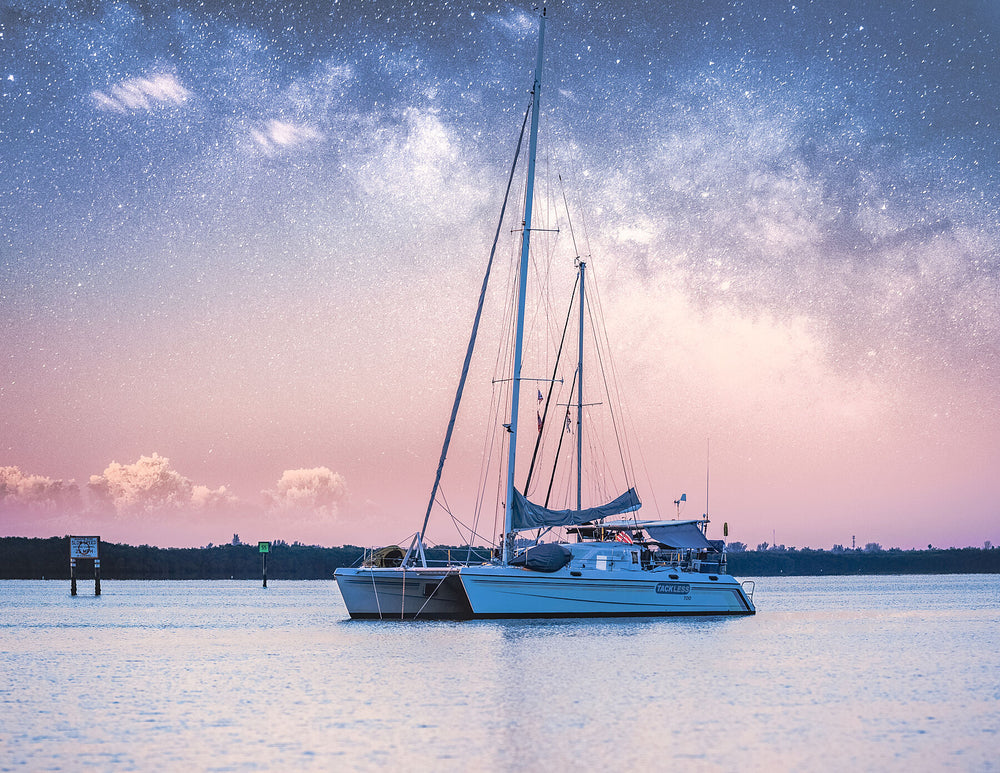 Catamaran anchored beneath the Milky Way at twilight